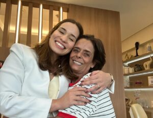 Dentista da clínica Herrera Prime abraça paciente feliz com seu novo sorriso após implante zigomático em São José dos Campos.
